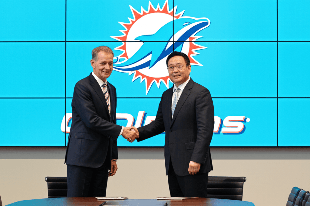 Lin Bin and Stephen Ross shake hands, announcing the Dolphins minority stake deal.